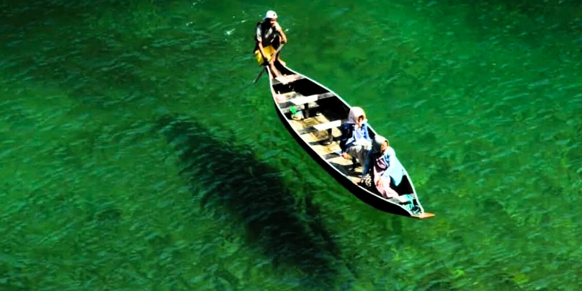 Boating on clear Umngot river with surrounding greenery